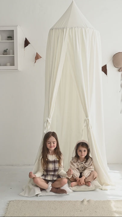 Cozy reading nook with white linen canopy for kids